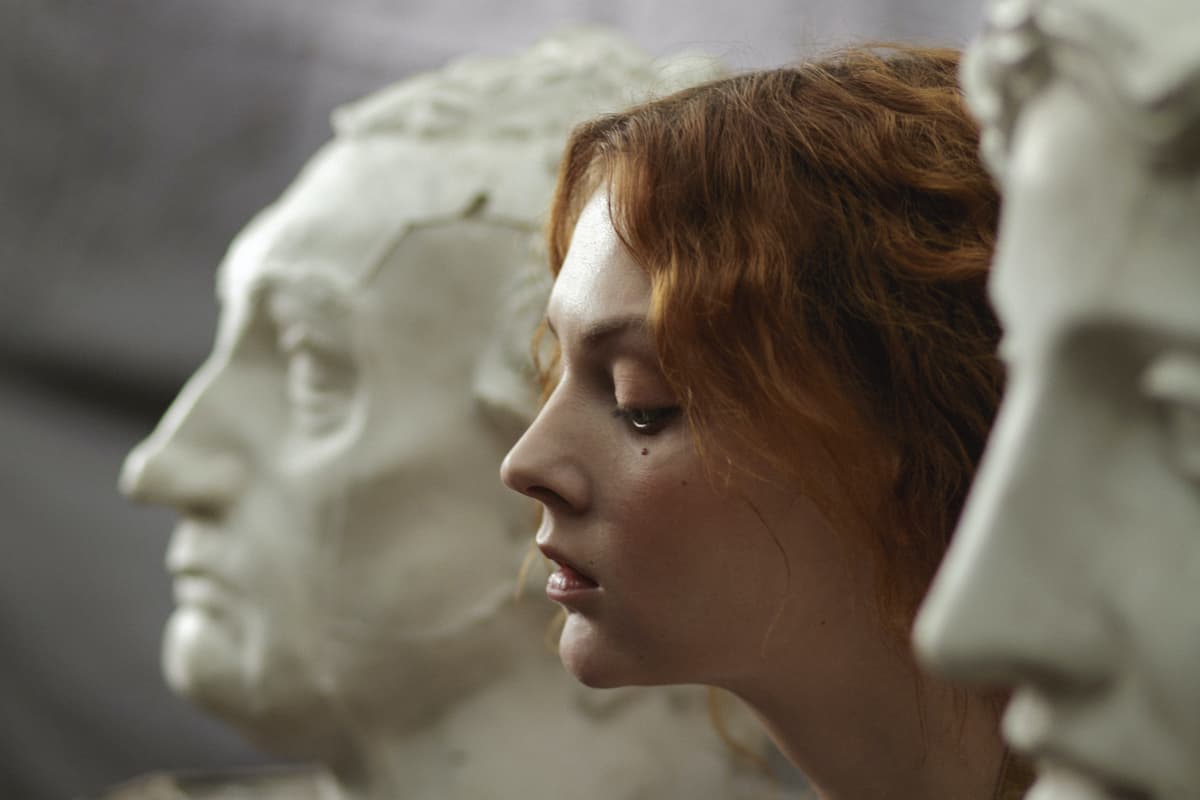 introverted girl thinking amond two statue heads